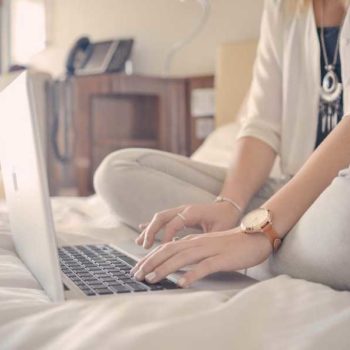 photo femme avec un lit avec son ordinateur
